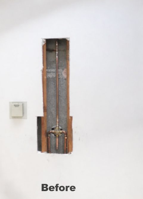 Open wall cavity with plumbing exposed before drywall repair